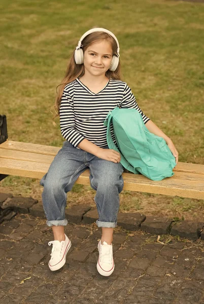 Bambino felice ascoltare musica in cuffie moderne seduti sulla panchina del parco estate all'aperto, vacanza — Foto Stock