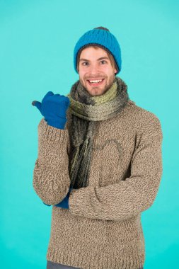 Grip yok. Kış hava tahmini. Adam kalın kıyafetler giyiyor. Erkek örgü modası. Erkekler kumaş ve aksesuar örer. erkek mavi arka plan. Zavallı evsiz adam. Mutlu adam kışın üşüyor