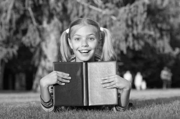 School time. Developing caring learners who are actively growing and achieving. Little child reading book outdoors. Schoolgirl reading stories while relaxing green lawn. Cute pupil enjoy reading — Stock Photo, Image