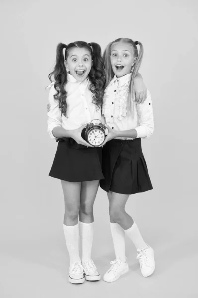 Retourner en classe à temps. Joyeuses petites filles de retour à l'école le 1er septembre. Petits écoliers souriant avec horloge. Bon retour. Je commence une nouvelle année. La rentrée scolaire est une nouvelle étape vers l'avenir — Photo