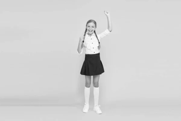 Aluna emocional. Celebre o dia do conhecimento. Hora de Setembro para estudar. Menina pupila adorável no fundo amarelo. Uniforme escolar e moda. De volta à escola. Estudante criança adora escola — Fotografia de Stock