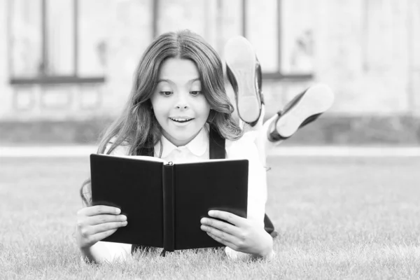 Não poderia haver verdade sem informação. Criança pequena recebe informações do livro da biblioteca. Menina bonito ler na grama verde. Informação da escola. Educação e informação — Fotografia de Stock