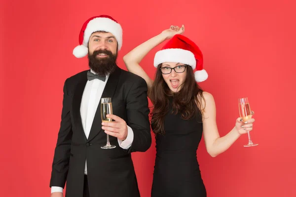 Boldog új évet! Boldog karácsonyt! Az üzleti pár pezsgőt iszik. Karácsonyi irodai buli. Imádják az új évet. Üdvözletem. hivatalos pár látogató esemény szertartás. szmoking férfi nő télapó kalap — Stock Fotó