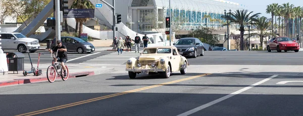 カリフォルニア州ロングビーチ2021年4月12日:アンティークベージュのレトロヴィンテージ車のカブリオレとサイクリスト — ストック写真