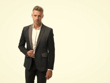 Yakışıklı, olgun bir adam resmi iş stili takım elbise giyer. Moda, özel dikim, mekan kopyası.