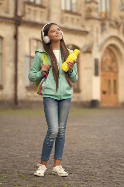 Kulaklıklarda meyve suyu ya da su şişesi olan çocuk sağlık ve vücut suyu, su dengesi