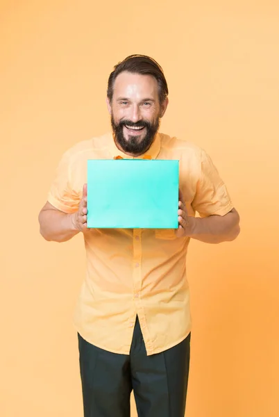 Bolsa de regalo. Hombre feliz mantenga bolsa de compras fondo amarillo. Bolsa de papel para la venta de moda. Bolsa de regalo. Preparación y celebración navideña. Empaque y paquete. Aniversario de cumpleaños, espacio para copiar —  Fotos de Stock