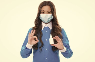 Çocuk burun akıntısını burun spreyiyle tedavi ediyor. Dolgun burnunu serbest bırak. İlaç bağımlılığı yok. Çocuk eczanede maske takıyor. Coronavirus covid salgını. Burun damlası olan kız. Virüsün ilk belirtileri