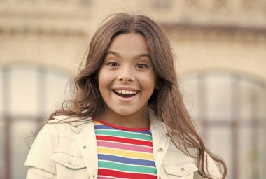 Küçük kız muhteşem saç stili sevimli gülümseme şehir geçmişi, neşeli gün konsepti