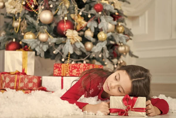 Dreaming her Christmas dream. Little child sleep at Christmas tree. xmas eve. Boxing day. New year presents and gifts. Holiday season is here