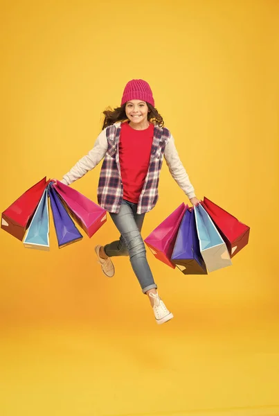 Ort, an dem man Emotionen kauft. Energetische Shopping-Süchtigen gelben Hintergrund. Glückliche Kinder tragen Einkaufstüten. Verkauf und Einkauf. Cyber Monday. Schwarzer Freitag. Shop Kinderbekleidung und Babybekleidung — Stockfoto