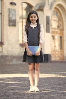 Okul üniformasını geri getirmek. Mutlu çocuk açık havada okul modasında üniforma giyiyor. Resmi tarz. Kıyafet standartları. İlköğretim. 1 Eylül. Bilgi günü