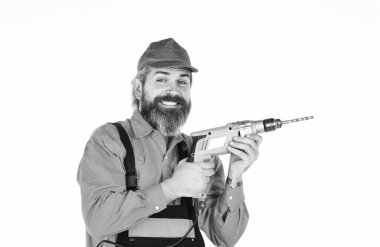 Güçlü matkap. Matkap al. Tamirci delik açıyor. Güvenlik önlemleri. Sondaj konsepti. Duvarı delmek için taş ustası olmak lazım. Beyaz arka planı delinmiş şapkalı bir adam. Perforatör ve bit