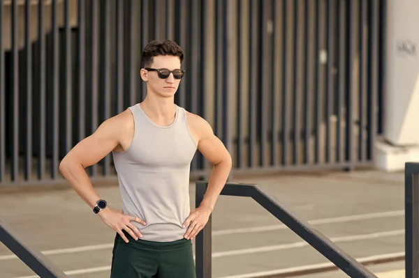 Beau sportif en lunettes de soleil prêt pour le jogging matinal au stade — Photo