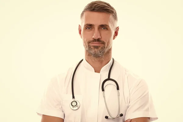 Médico terapeuta hombre maduro sonriente con la cara sin afeitar en traje médico y estetoscopio cuidar su salud aislada en blanco, medicina — Foto de Stock
