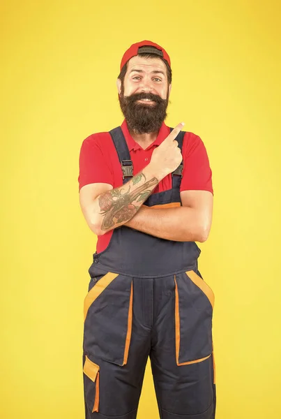 Regarde par là. service de mécanicien mature. plombier qualifié. réparateur après avoir terminé les travaux. brutal homme barbu en uniforme. Un ouvrier en salopette et casquette. ouvrier constructeur ou ingénieur — Photo