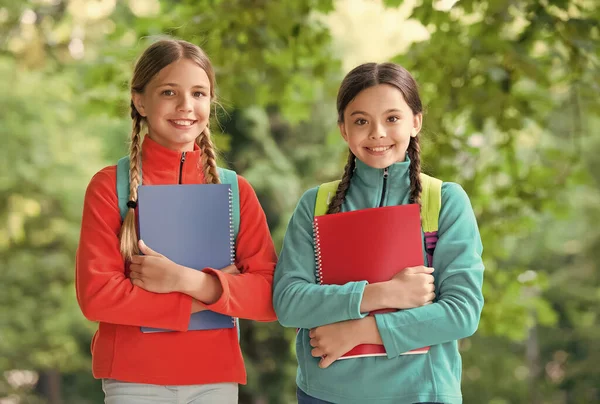 Schoolmeisjes met rugzakken en lesboeken in bos, zomerkamp activiteitsconcept — Stockfoto