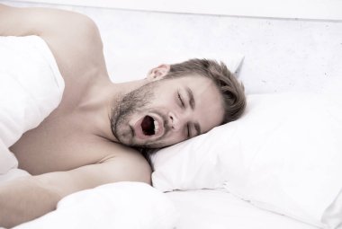 Uyuyor ve uyanık. Seksi adam yatakta uyuyor. Günaydın. Tatlı rüyalar. Erkek sağlığı ve bekar yaşam tarzı. Adam derin uykuda. Yatak odasında dinleniyor. Enerji ve yorgunluk. sabah seks konsepti
