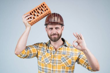 labor or workers day. man laborer with brick. guy wear worker uniform. handsome builder in helmet