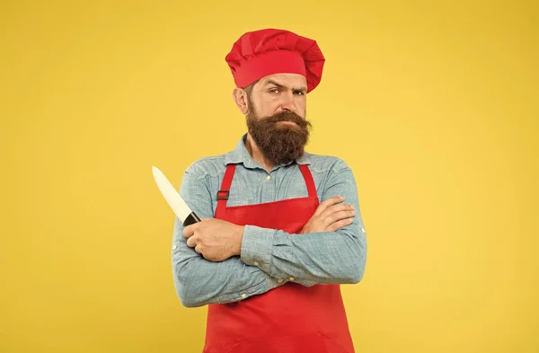 Chef knappe bebaarde kok in rood uniform houden scherpe professionele mes — Stockfoto