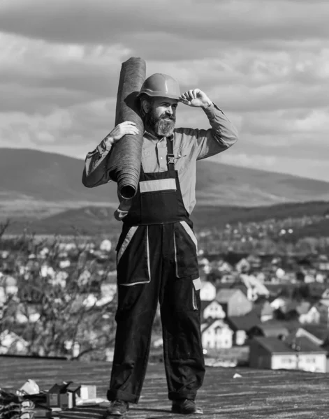 Installazione tetto piano. Uomo cappello duro lavoro all'aperto paesaggio sfondo. Edificio. Installare barriere al vapore o strati di isolamento su tetti piani. Roofer sta costruendo il tetto. Master riparazione tetto — Foto Stock