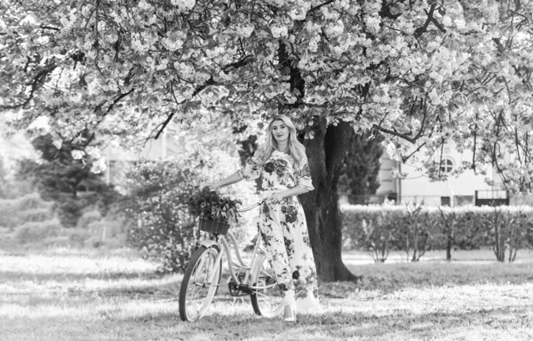 Sakura season. Woman with tulips bouquet. Sakura tree blooming. Romantic bike ride. Girl long dress retro cruiser bicycle sakura tree. Spring holidays. Tourism concept. Transportation and travel — Stock Photo, Image