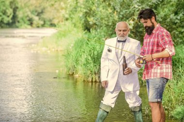 Hafta sonu tatili. Balık tutma becerileri. Yaz hafta sonları ya da tatil. Balık tutma bahanesi. Sakallı adam ve zarif iş adamı birlikte balık tutuyor. - Şerefe. Erkekler doğayı rahatlatıyor. Eğlen ve rahatla.