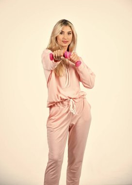 Güzel kadın dambılla egzersiz yapıyor. Spor ve spor giyim tarzı. Spor malzemeleri dükkanı. Kadın fitness modası. Pembe halterli kız. Koçla fitness antrenmanı. Eller için egzersiz