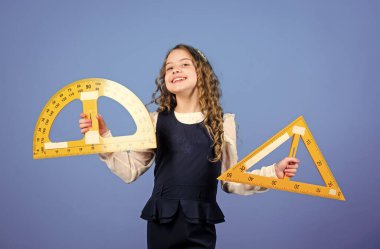 Okul eğitimi konsepti. Matematik öğren. Teoriler ve aksiyomlar. Zekice ve zekice bir fikir. Boyut ve boyut. Büyük cetveli olan kız. Öğrenci geometri okuyor. Çocuk okulu üniforması. Cetvel.