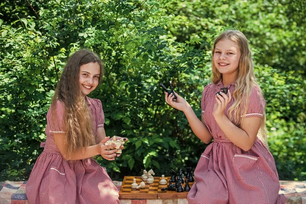 Настольная игра. планирование стратегии с шахматными фигурами. Логическая игра для развития мозга. успешная игра. Две девочки играют в шахматы в парке. дети-ретро шахматисты. концепция стратегии — стоковое фото