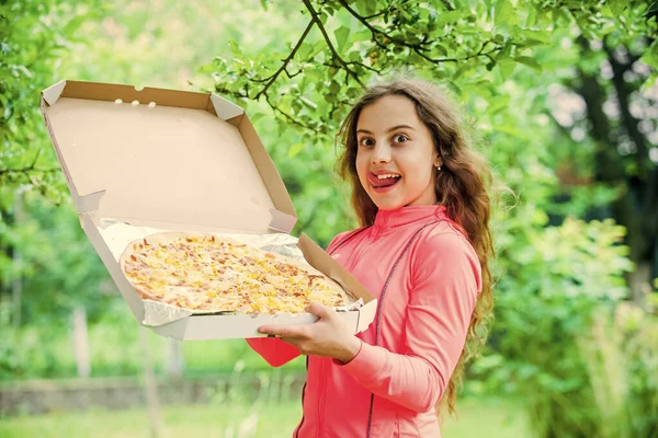 Το κοριτσάκι τρώει πίτσα. Παράδοση πίτσας. ανθυγιεινά και υγιεινά τρόφιμα. Χαρούμενη παιδική ηλικία. Το παιδί πεινάει. Το πεινασμένο παιδί θα φάει ιταλική πίτσα. έννοια fast food. Χαρούμενη ημέρα των παιδιών — Φωτογραφία Αρχείου