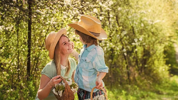 Profiter du temps ensemble. Bonne famille. Des émotions humaines positives. des sentiments de joie. cueillir des fleurs d'été dans le parc. Relation familiale. mère s'amuse avec son enfant. Portrait de mère et fils heureux — Photo