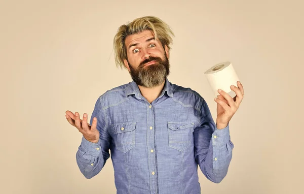 Acheter des biens essentiels. Crise du papier toilette et que faire en cas de panne. Utilisez la calculatrice pour empêcher l'accumulation de papier hygiénique. Un homme tient du papier toilette. Hipster avec des tissus. limiter l'utilisation. Boutique en ligne — Photo