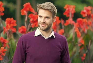 Süveterli, modaya uygun gülümseyen adam.