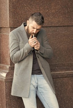 Sakallı hippi, şık saçlı, ceketli, kot pantolonlu, sigara içen, hippi tarzı bir adam.