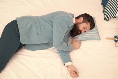 İyileş, normal ruh haline dön. Bir uzun gün daha bitti. Yorgun ve uykulu hissediyorum. Resmi giysiler içindeki uykulu adam yatakta uyuyor. Uykusuzluk. Biraz daha uyumam lazım. Akşam vakti. İşadamı yorgun.