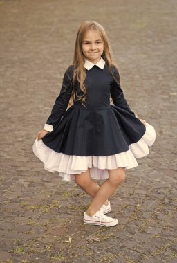 Zarif ve zarif. Mutlu çocuk dışarıda üniformalı reverans yapıyor. Kıyafet kuralı. Resmi tarz. Moda okulu üniforması. Kıyafet standartları. İlköğretim. 1 Eylül