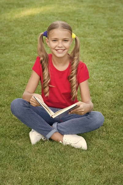 Μικρό κορίτσι χαριτωμένο κόμμωση ανάγνωση βιβλίο χαλαρωτική φύση φόντο, πίσω στο σχολείο έννοια — Φωτογραφία Αρχείου