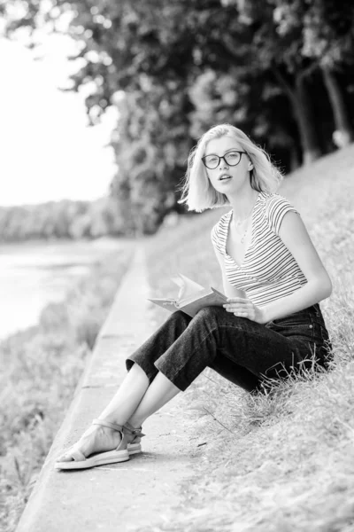 Rest relax and hobby. Spend free time for yourself. Vacation season. Summer vacation. Girl sit on green grass near river. Girl relaxing at riverside after working day. Woman dreaming about vacation — Stock Photo, Image