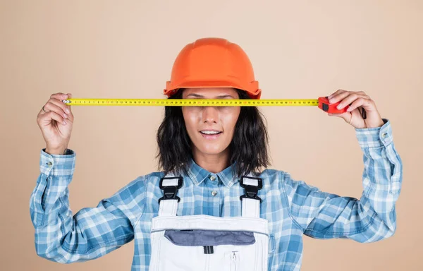 Счастливая женщина строитель в защитном шлеме использовать рулетку мера, размер — стоковое фото