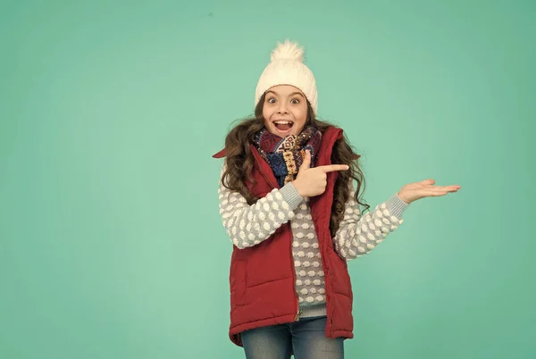 Sıcak kış kıyafetleri içinde neşeli bir çocuk. Yeni yıl tatilinde örgü şapka ve kazak giyer. Ürün sunar, reklam için fotokopi alanı, xmas alışverişi. — Stok fotoğraf