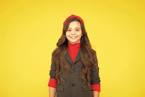 Gelukkig klein meisje kind glimlach in school uniform geel achtergrond, schoolmeisje — Stockfoto