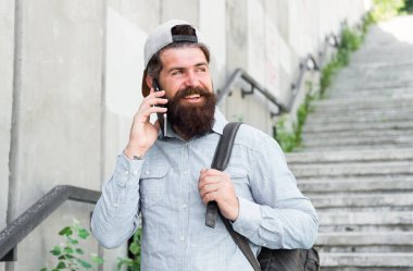Mutluluk seyahat ediyor. Sakallı adam telefonda konuşuyor. mutlu acımasız adam sokakta yürümek. Erkek berber bakımı. sırt çantası ile acımasız hipster. yürüyüş macera konsepti. kentsel tarzı. Olgun hipster gezgin