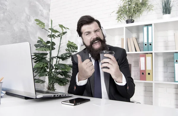 El mejor café de la ciudad. Abogado dar pulgares hacia arriba con la taza de café. El agente inmobiliario bebe café para llevar en la oficina. Hombre barbudo disfrutar de un descanso de café en el lugar de trabajo. Vida de oficina. Trabajo diurno. Descanso en el trabajo — Foto de Stock