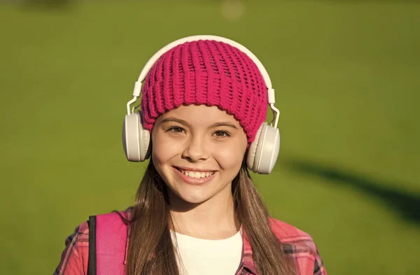 La música te hace más inteligente. Chica feliz escuchar música soleada al aire libre. Los niños pequeños usan auriculares tocando música. Vacaciones de verano. Diversión y entretenimiento. Nueva tecnología. La vida moderna. Entrar en el surco — Foto de Stock