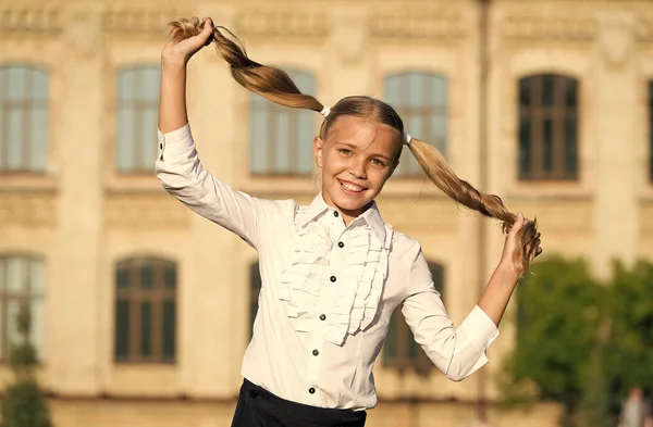 Klein meisje spelen met lange gezonde glanzende kapsel, schattig kapsel concept — Stockfoto