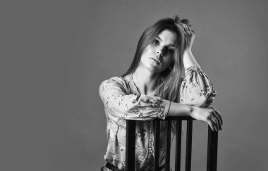 Sadece dinleniyorum. Güzel bir kadın yüzü. Kadın modası. Uzun saçlı kız sandalyeye oturur. Rahatlama konsepti. Kadın rahat yüzü sandalyede tek başına oturuyor. Düşünceleriyle baş başa. Languid bakışı. Rahat duruş