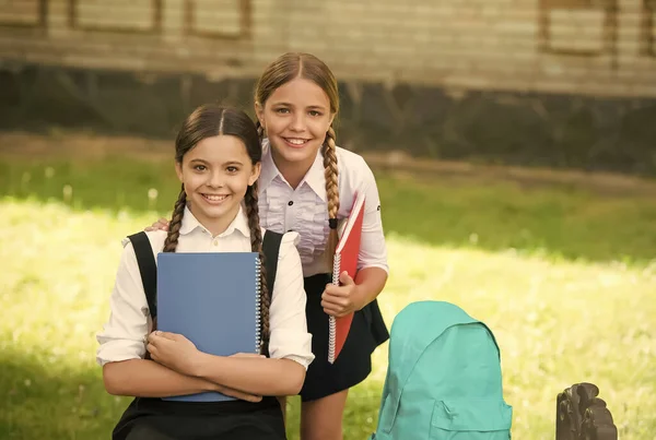 Niños felices en uniforme tienen libros escolares para hacer tareas al aire libre, educación —  Fotos de Stock