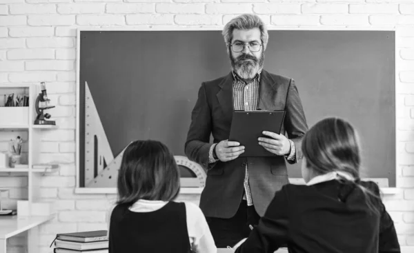 Leraar en kinderen klaslokaal. Discussiegroep van kinderen en leraar. Dialoog en communicatie. Dagelijks schoolleven. Vrienden studeren samen. Terug naar school. Hulp en ondersteuning. Leraar in het basisonderwijs — Stockfoto