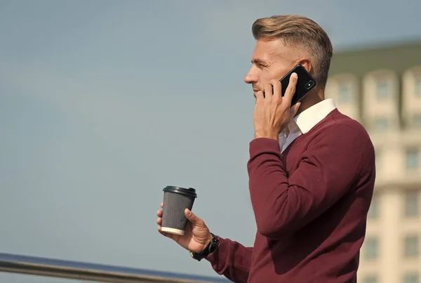 Usando tecnologías de comunicación. Un tipo guapo habla por teléfono bebiendo café al aire libre. Comunicación móvil. Conversación telefónica y comunicación. Comunicación empresarial. 3G. 4G. La vida moderna — Foto de Stock